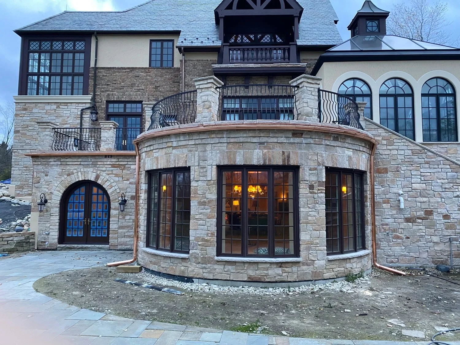 Copper gutters wrapping curved stone estate