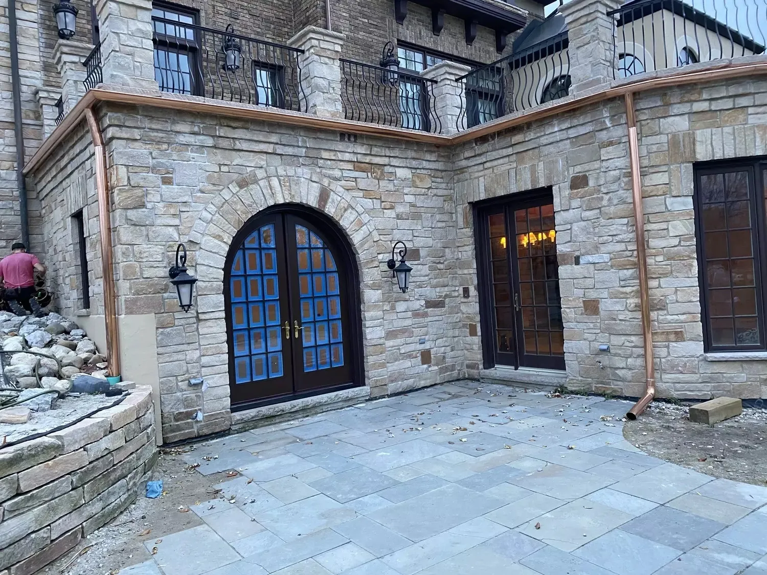 Copper gutters and downspouts on stone courtyard