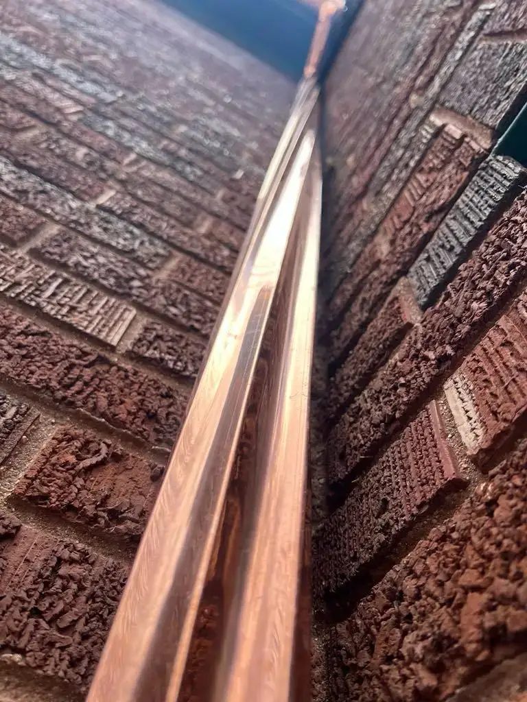 Custom half round copper gutters and twisted downspouts — photo 9