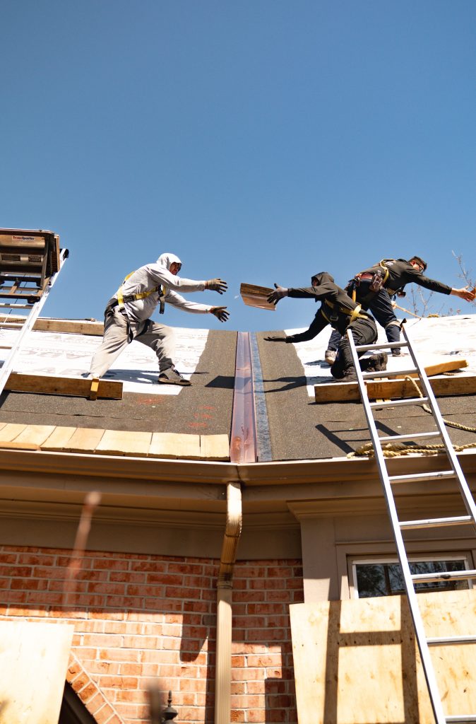 Crew installing copper flashing on a residential roof