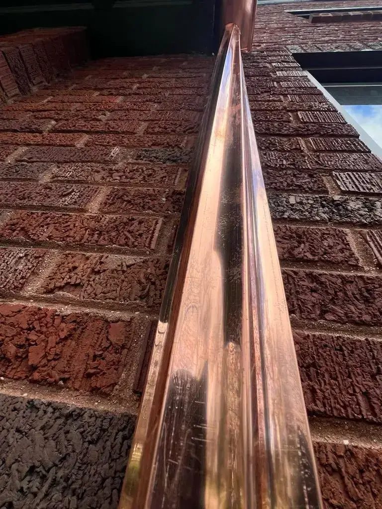 Custom half round copper gutters and twisted downspouts — photo 7